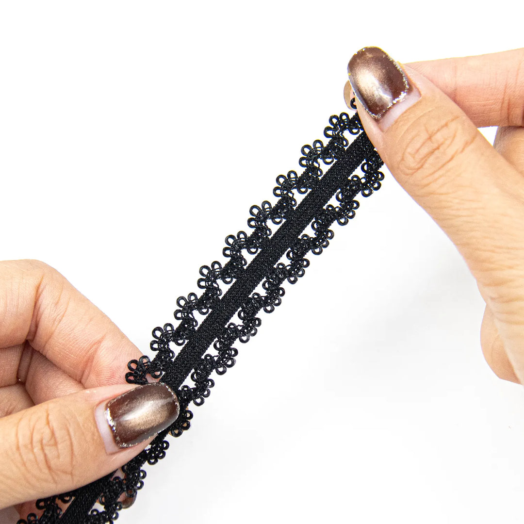 Hands stretching the black elastic lace band to show its flexibility.