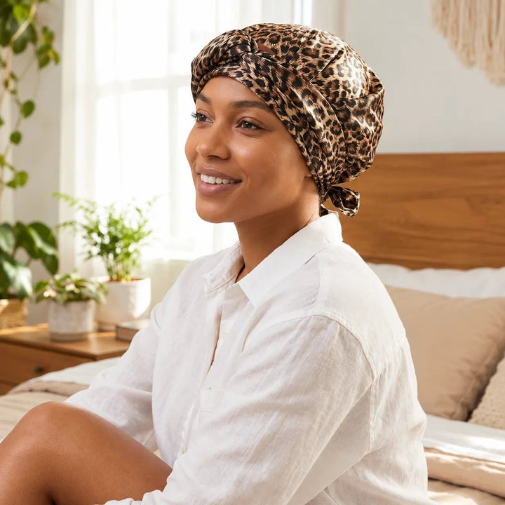 Side angle of model wearing Ywigs Leopard Print Satin Hair Scarf with Mesh Cap showing the breathable mesh cap and flowing satin scarf